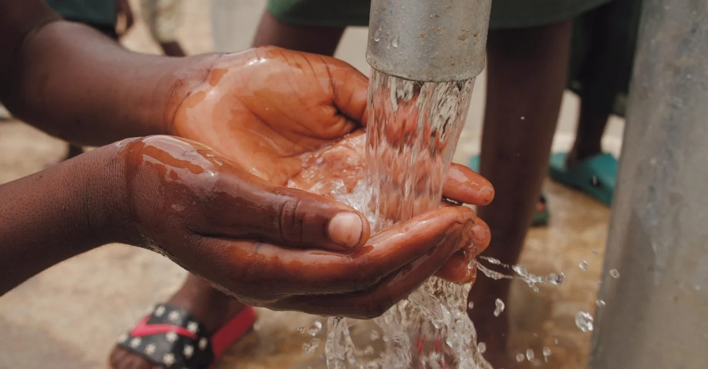 a child s hands catching water from the spout